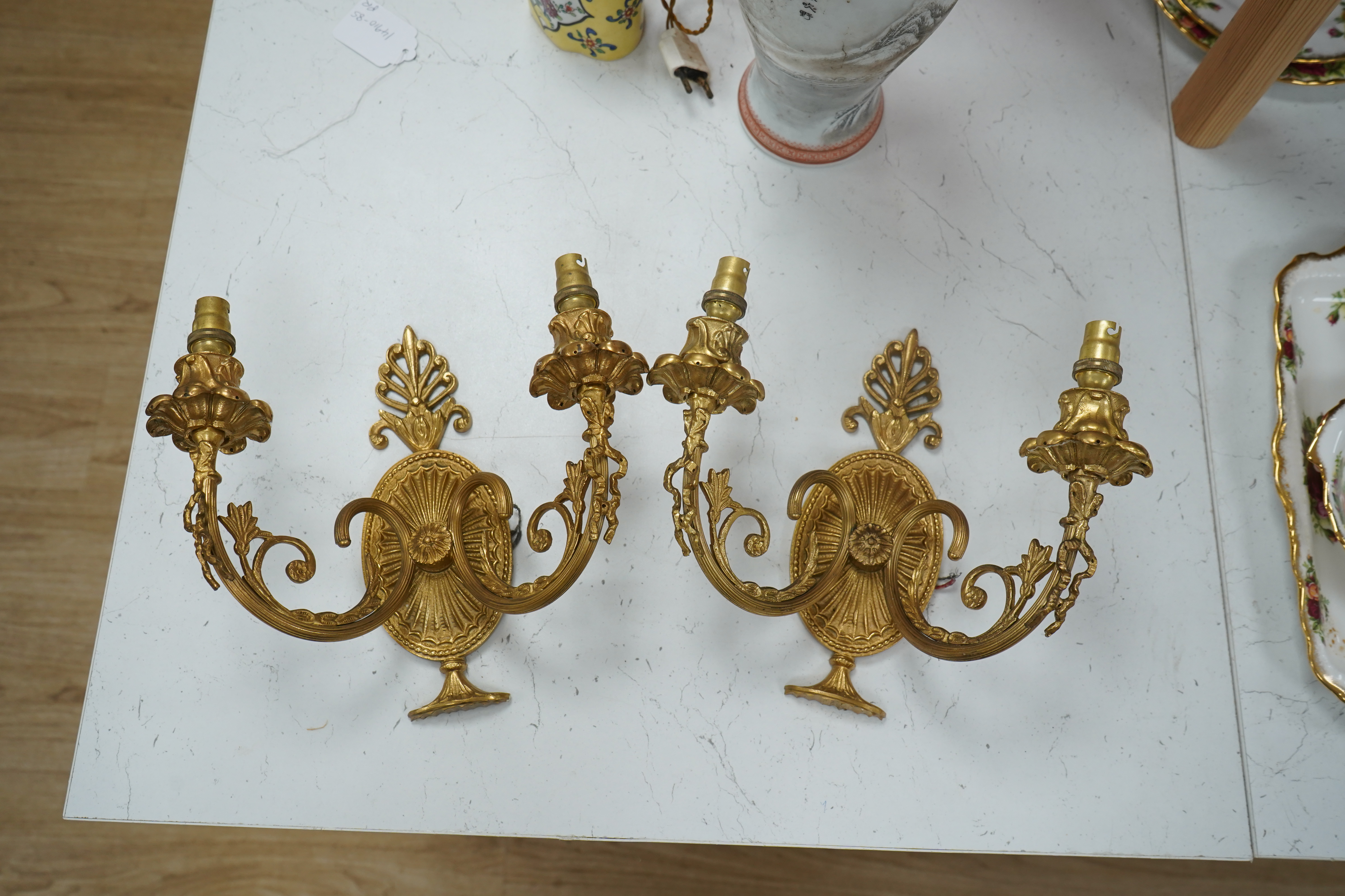 A pair of Adam style gilt brass twin branch wall lights, 23cm long. Condition - good